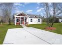 The front exterior of a charming home, featuring a well-manicured lawn and a paved driveway under a bright, sunny sky at 1244 Bob Falls Rd, Shelby, NC 28150
