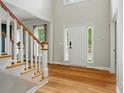 Bright foyer with gleaming hardwood floors, white door, and staircase leading to the upper level at 138 Montibello Dr, Mooresville, NC 28117
