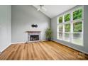 Spacious living room with a cozy stone fireplace, large windows, vaulted ceilings and light hardwood floors at 138 Montibello Dr, Mooresville, NC 28117