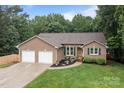 Attractive brick home with two-car garage, green shutters, and beautiful front garden at 144 Sea Trail Dr, Mooresville, NC 28117