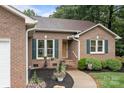 Charming brick home with lush landscaping, a sidewalk, and dark green shutters at 144 Sea Trail Dr, Mooresville, NC 28117