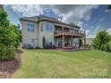 Expansive backyard featuring a spacious deck, covered patio, and lush greenery at 14503 Crest Ct, Charlotte, NC 28278