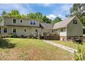 View of the back of a house with a lawn, deck, and brick pathway, creating an inviting outdoor space at 1818 Winfield Dr, Monroe, NC 28110