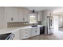 Modern kitchen with white cabinets, stainless steel appliances, and decorative backsplash at 2001 Lakeview Dr, Pineville, NC 28134