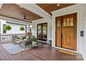 Relaxing front porch featuring comfortable seating, ceiling fan, wood flooring, and double door entry at 2615 Chesterfield Ave, Charlotte, NC 28205