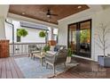 Inviting front porch with stylish furniture, wood ceiling, ceiling fan, and double doors to the interior at 2615 Chesterfield Ave, Charlotte, NC 28205