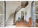 Grand foyer featuring a curved staircase, hardwood floors, and elegant chandelier lighting at 2630 Mary Butler Way, Charlotte, NC 28226