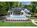 Beautiful backyard showcasing a luxurious pool, outdoor seating area and manicured lawn at 301 Riverwood Rd, Mooresville, NC 28117