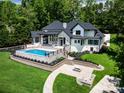 Aerial view of a modern home showcasing a stunning pool, fire pit, and lush green landscaping at 301 Riverwood Rd, Mooresville, NC 28117