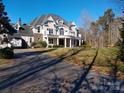 Impressive two-story home with a grand balcony, classic columns, and a neatly landscaped front yard at 450 Greywalls Ln, Iron Station, NC 28080