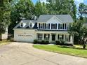 Inviting two-story home featuring a classic white exterior, black shutters, and a lovely front porch at 4504 Bellmore Ct, Charlotte, NC 28269