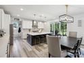 Bright kitchen with white cabinets, an island with seating, pendant lighting, and an adjacent dining area with access to the backyard at 4530 Tournette Dr # 18, Indian Land, SC 29707