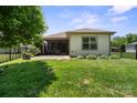 Well-maintained backyard with green grass, a patio area, and a black metal fence providing privacy at 4975 Looking Glass Trl, Denver, NC 28037
