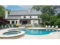 Outdoor oasis featuring a private pool, hot tub, lounging area, and meticulous landscaping at 5523 Meadow Haven Ln, Charlotte, NC 28270