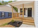 Inviting front porch with wooden railings and a stylish black door, enhancing the home's curb appeal at 626 W Bell St, Statesville, NC 28677