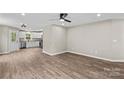 Open living space featuring vinyl floors that connect to the kitchen with white cabinets and stainless appliances at 626 W Bell St, Statesville, NC 28677