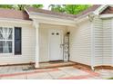 Close-up of home's front entrance with sidelight, covered porch and 'Home' welcome decor at 7442 Crestside Ln, Charlotte, NC 28227