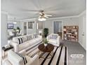 Bright living room featuring modern decor, striped rug, ceiling fan, and seamlessly connected dining area at 752 Raindrops Rd, Gastonia, NC 28054