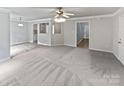Neutral living space showcasing carpet, ceiling fan, and a view into the adjacent kitchen at 752 Raindrops Rd, Gastonia, NC 28054