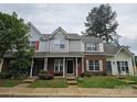 Exterior shot of townhomes showcasing brick and siding, inviting porches, and well-maintained landscaping for curb appeal at 7562 Petrea Ln, Charlotte, NC 28227