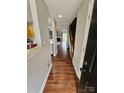 Inviting hallway with beautiful hardwood floors leads to a bright living space with a fireplace and staircase at 7562 Petrea Ln, Charlotte, NC 28227