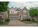 Charming stone and siding two-story home with a two-car garage and well-manicured lawn at 7913 Waverly Walk Ave, Charlotte, NC 28277