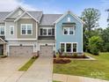 Charming townhome showcasing craftsman-style architecture, a 2-car garage, and a landscaped yard at 8215 Houser St, Cornelius, NC 28031