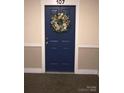 Blue front door #107 is decorated with a cheerful wreath at 1000 E Woodlawn Rd # 107, Charlotte, NC 28209