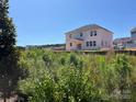 Exterior view of a two-story home with a white exterior, black roof and lush grassy landscape at 1005 Cunningham Farm Dr, Indian Trail, NC 28079