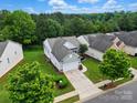 An aerial view of a home with well-maintained landscaping, a driveway, and surrounded by lush trees at 1030 Pinehurst Ln, Fort Mill, SC 29707