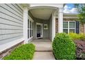 Inviting front porch with stone accents, white pillars, and a glimpse of the stylish entrance door at 1030 Pinehurst Ln, Fort Mill, SC 29707