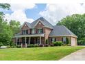 Beautiful brick home with attached garage, lush lawn, and covered front porch at 106 Hannaford Pl # 15, Gastonia, NC 28052