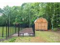 Outdoor storage shed located in fenced backyard with mature trees at 106 Hannaford Pl # 15, Gastonia, NC 28052