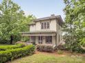 An idyllic property showcasing a covered porch, lush greenery, and serene surroundings at 1120 N College St, Mount Pleasant, NC 28124