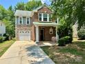 Beautiful two-story home with a brick and stone exterior, featuring a well-manicured lawn and greenery at 13913 Pinyon Pine Ln, Charlotte, NC 28215