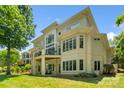 Back exterior of home featuring large windows, a balcony, and a spacious yard at 14515 Nolen Ln, Charlotte, NC 28277