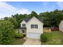 Two-story house with manicured lawn and an attached garage is surrounded by lush trees at 1534 Piney Church Rd, Concord, NC 28025