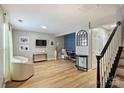 Light filled living area offers stylish blue accent wall, modern light fixture, and durable flooring at 15639 Sir Charles Pl, Charlotte, NC 28277