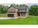 Charming two-story home with brick and siding exterior, featuring an attached garage and manicured front lawn at 207 9Th Ne Ct, Conover, NC 28613