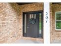 Close up of the front door with a wreath, brick facade, and white pillar with the house number at 207 9Th Ne Ct, Conover, NC 28613