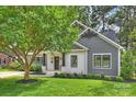 A beautifully renovated home exhibiting gray siding, white brickwork, a manicured lawn, and fresh landscaping at 3163 Maury St, Charlotte, NC 28208