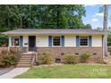 Attractive single-story home boasting blue shutters, a brick facade, and manicured landscaping at 3900 Langley Rd, Charlotte, NC 28215