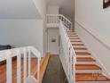 Bright foyer featuring hardwood stairs, a stone tile floor, and white railings at 4025 Woodfox Dr, Charlotte, NC 28277