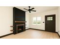Bright living room featuring a modern fireplace with wood accents, a ceiling fan, and a window offering natural light at 415 S Boyd St, Gastonia, NC 28052