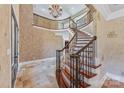 Grand foyer with winding staircase, decorative iron railing, chandelier, and high-end finishes at 534 N Ingleside Farm Rd, Iron Station, NC 28080
