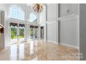 Spacious living room with high ceilings, French doors, and travertine floors at 534 N Ingleside Farm Rd, Iron Station, NC 28080