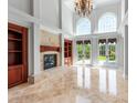Bright living room with fireplace, built-in bookshelves, soaring ceilings, and French doors at 534 N Ingleside Farm Rd, Iron Station, NC 28080