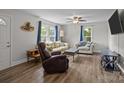 Bright living room featuring wood floors, neutral walls, a ceiling fan, and comfortable seating at 5371 Davidson Rd, Davidson, NC 28036