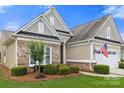 Charming home with lush landscaping, featuring brick and siding accents and an attached garage at 7036 Kitty Hawk Ln, Fort Mill, SC 29707