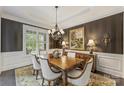 Dining area with hardwood floors, wainscotting, window with shutters, elegant chandelier and buffet at 7428 Edenbridge Ln, Charlotte, NC 28226